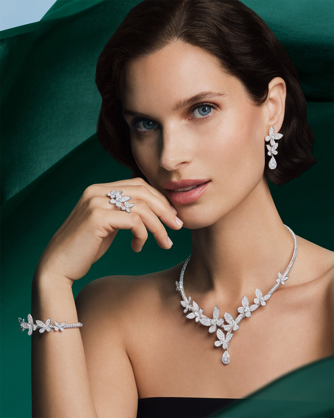 Image shows model wearing Graff Butterfly Pave White Diamond jewellery suite