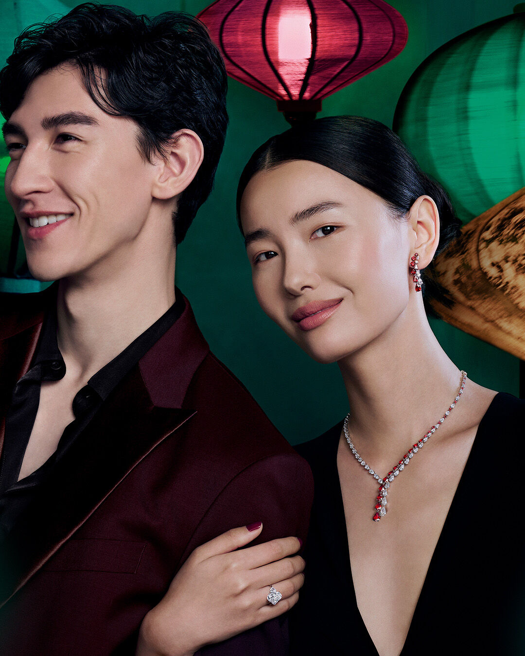 Image shows model wearing Graff Ruby and Diamond necklace and earrings and Graff Oval cut diamond engagement ring