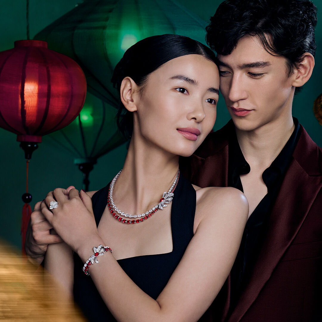 Lunar New Year gifts - image shows model wearing Graff diamond and ruby tilda's bow necklace, bracelet and oval cut diamond engagement ring