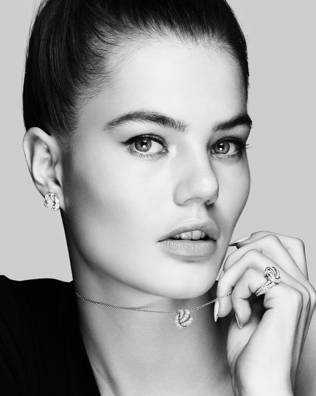 Close up of a black and white photo of a model wearing the Graff Tilda's Bow diamond jewellery