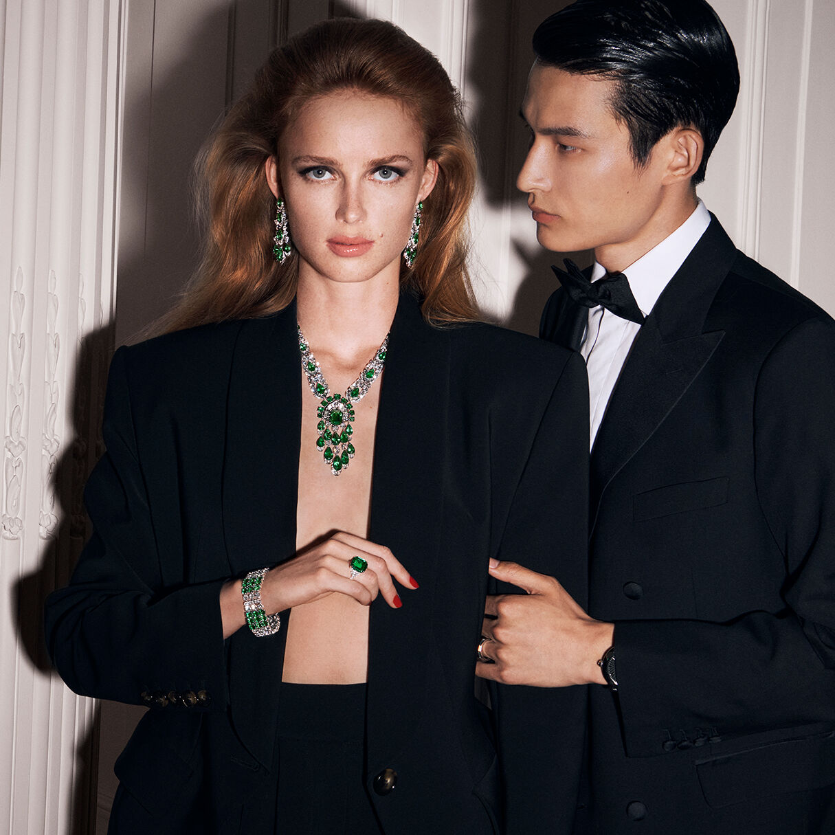 Female model wearing Graff Emerald High Jewellery Suite and male model wearing Graff Watch