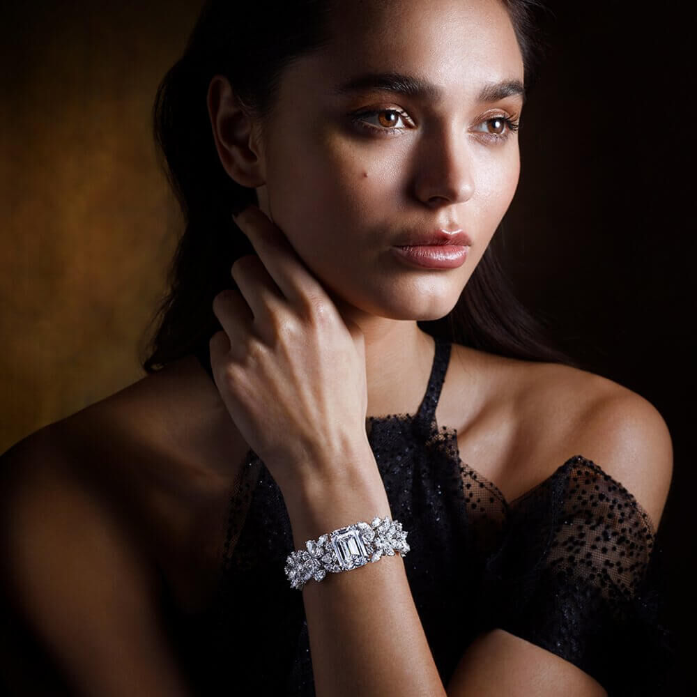 A lady wearing a Graff diamond bracelet featuring a 33.40 carat emerald cut diamond