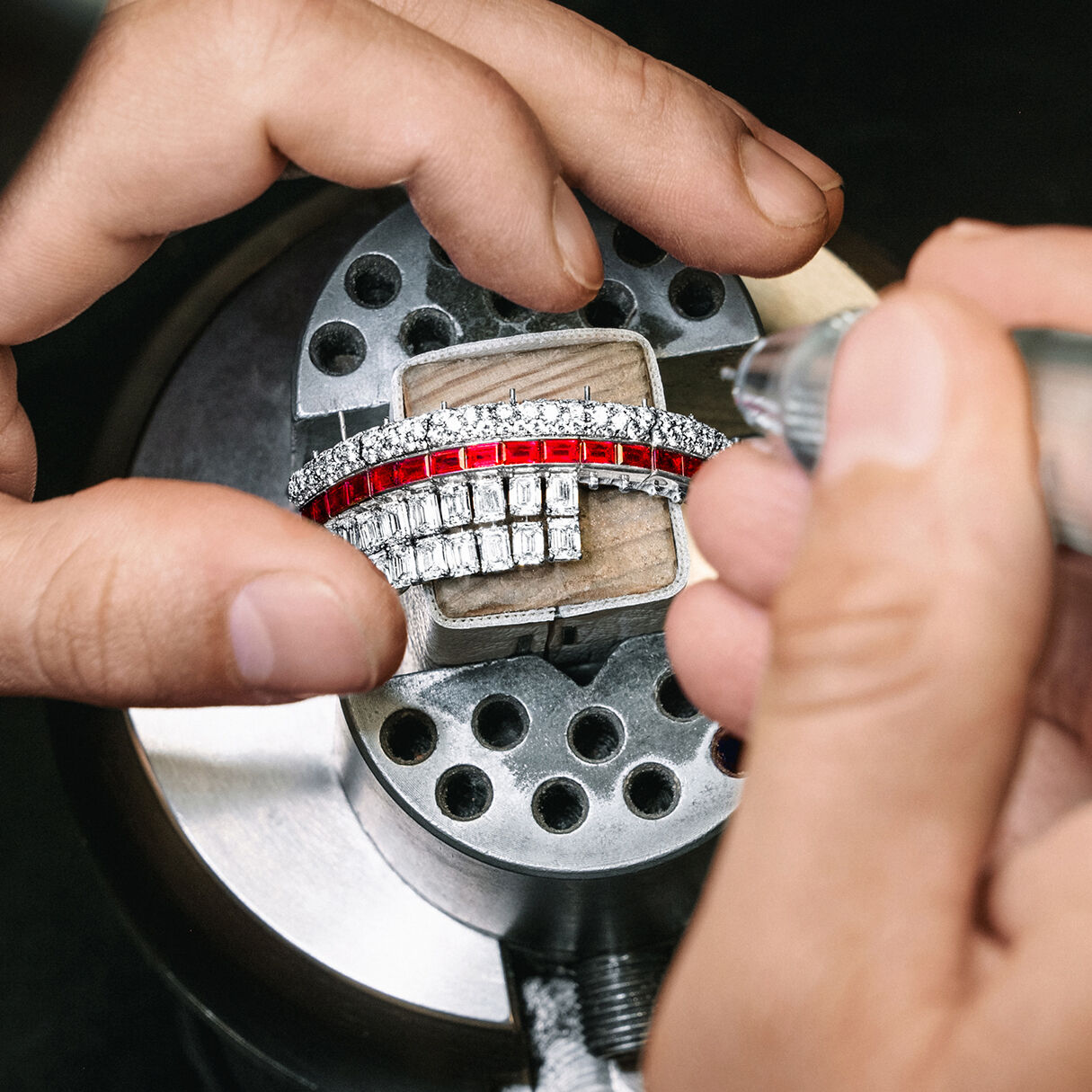 Graff craftsman holding Ruby and White Diamond High Jewellery bangle in Graff workshop