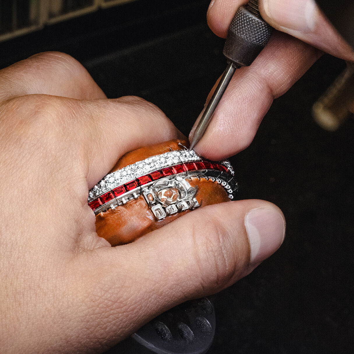 Graff craftsman holding Ruby and White Diamond High Jewellery bangle in Graff workshop