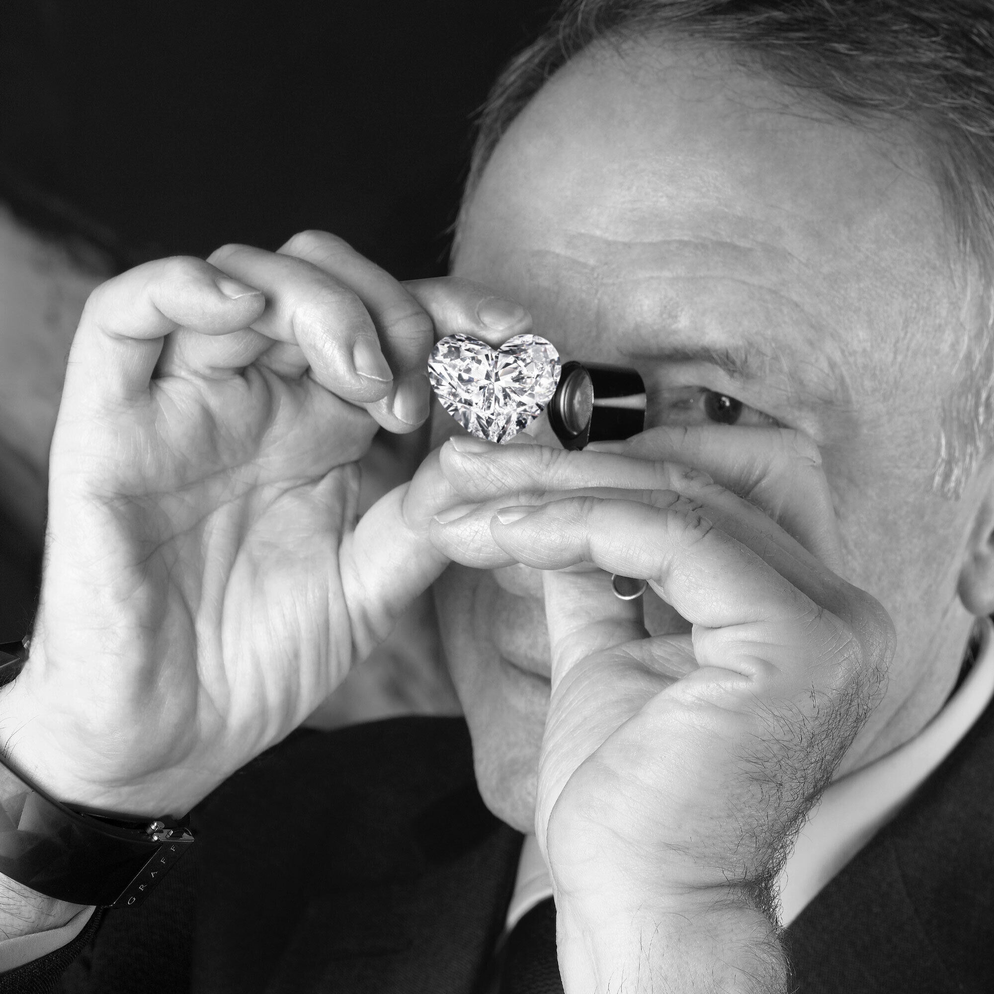 Mr Laurence Graff inspecting a heart shape diamond through a loupe