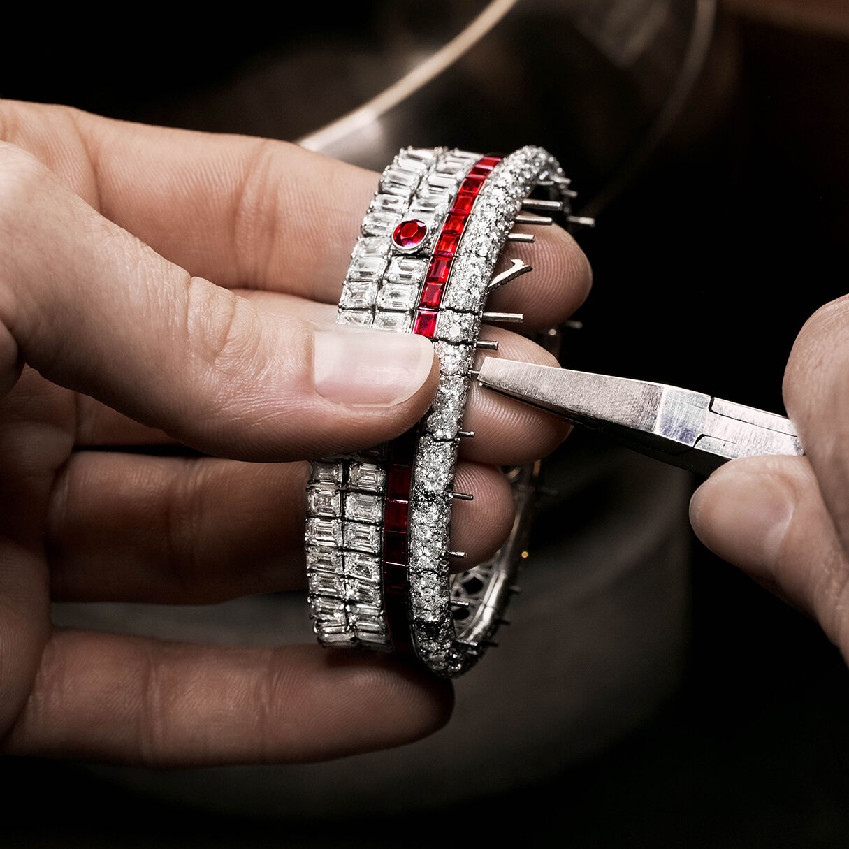 Graff craftsman holding Ruby and White Diamond High Jewellery bangle in Graff workshop