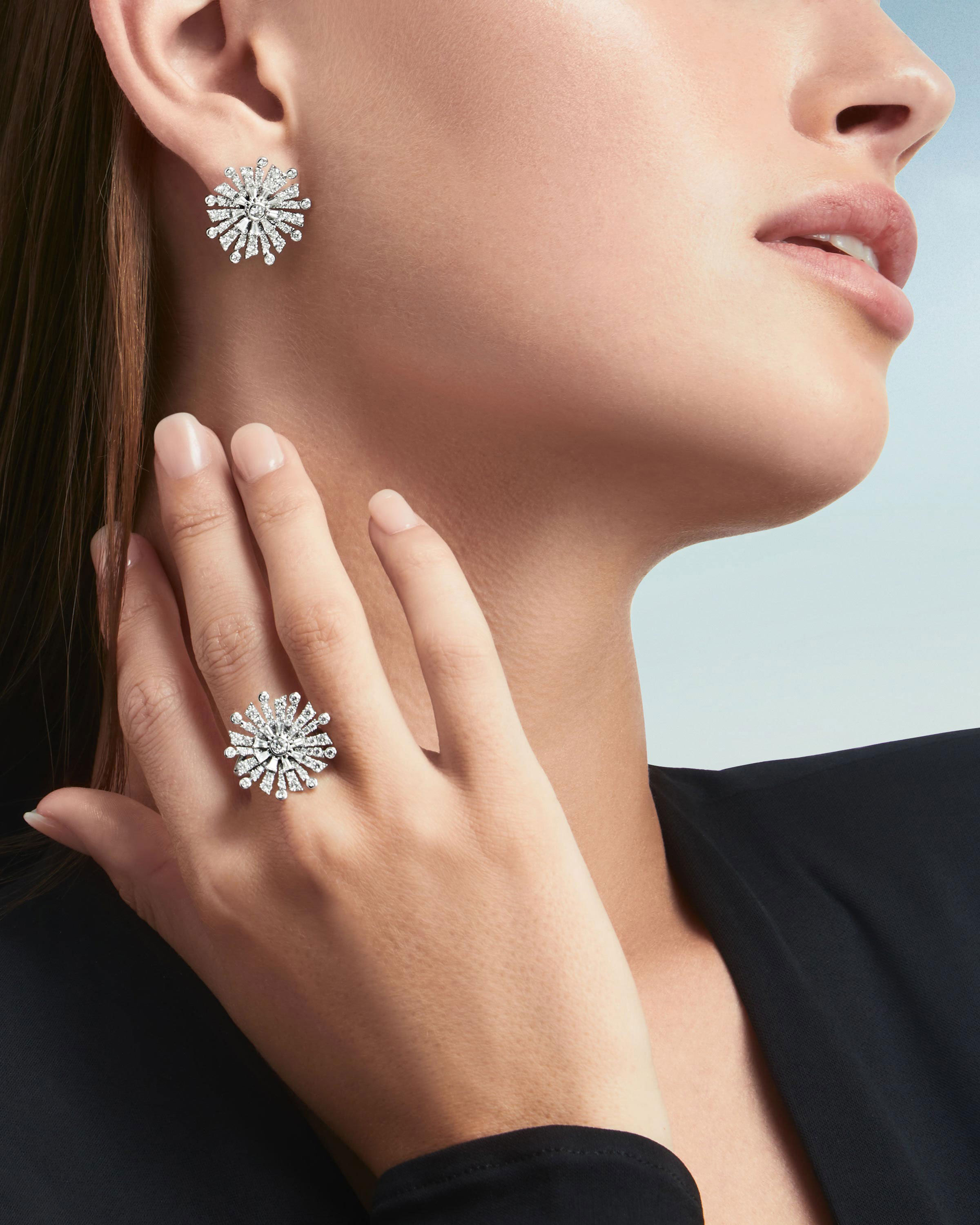 Close up of a model wearing the Graff New Dawn jewellery collection diamond earrings & ring