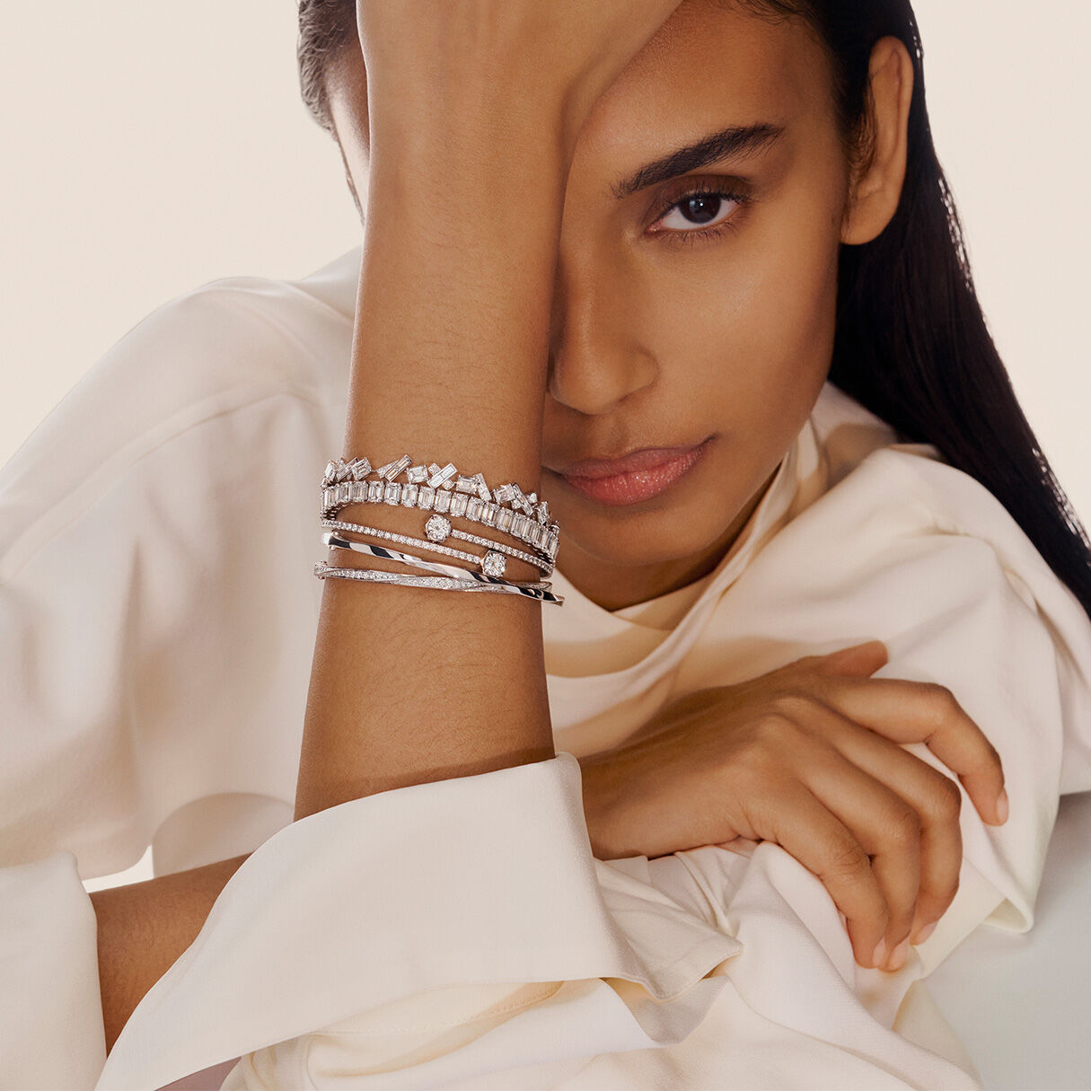 Stacking jewelry, model wears bracelets and bangles across multiple collections