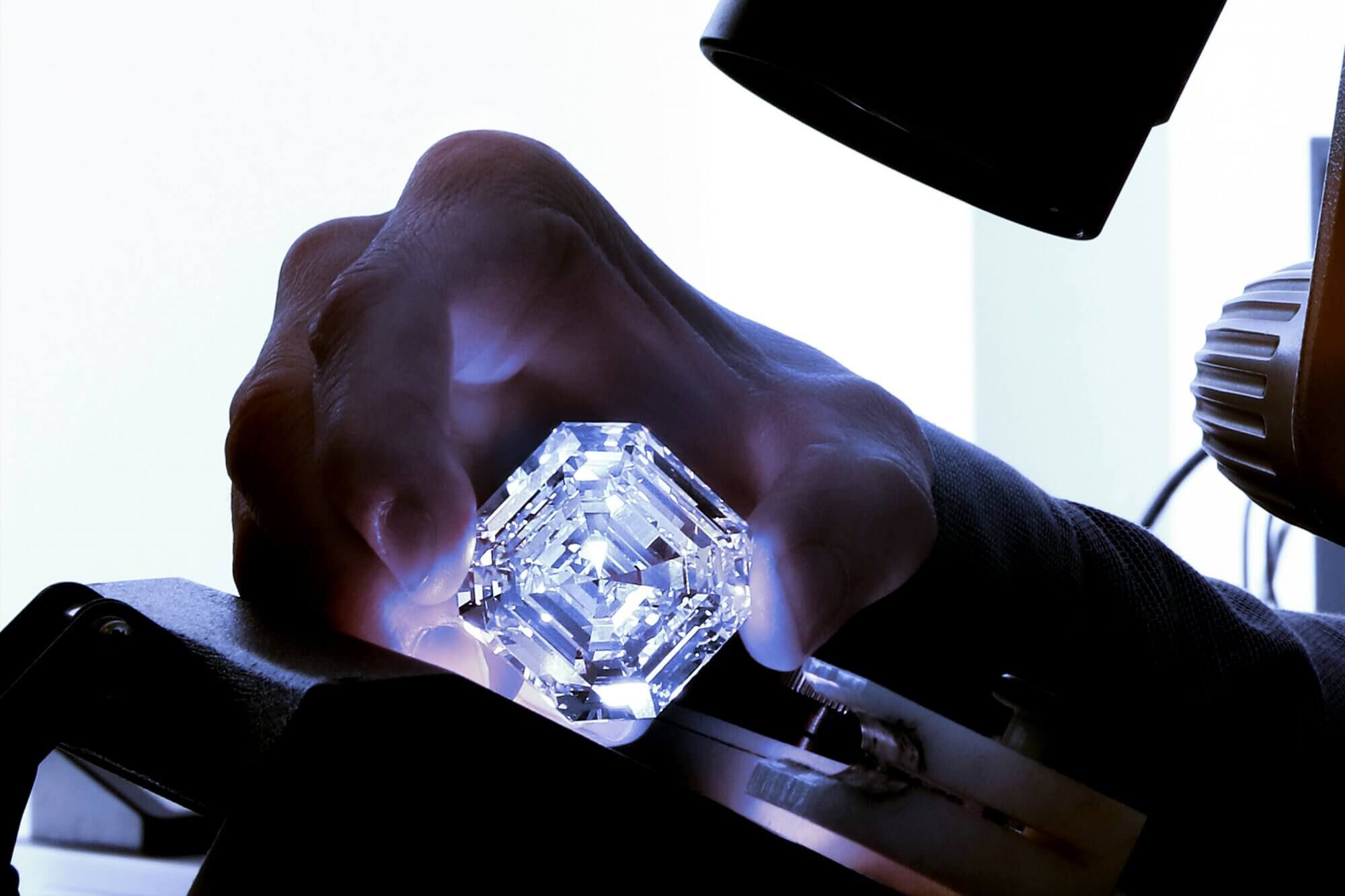 A Graff team member examining the Graff Lesedi La Rona Square Emerald Cut Diamond