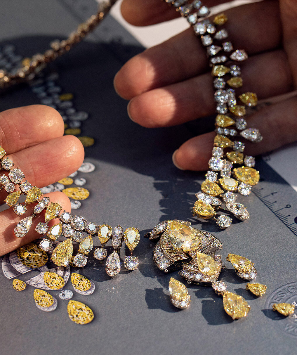 Craftsman holding Graff yellow and white diamond high jewellery necklace in Graff workshop