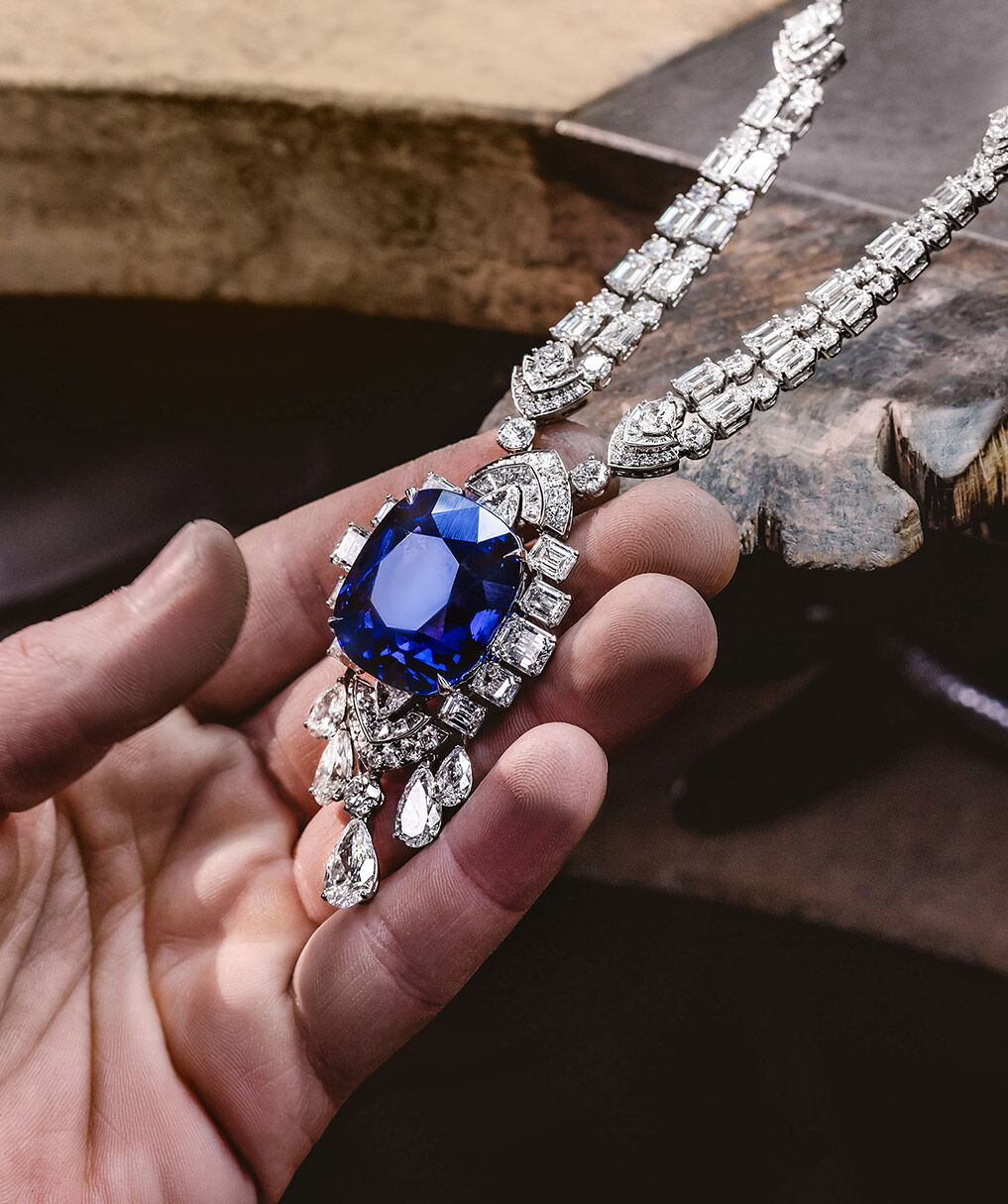 Craftsman holding Graff sapphire and white diamond high jewellery necklace in Graff workshop