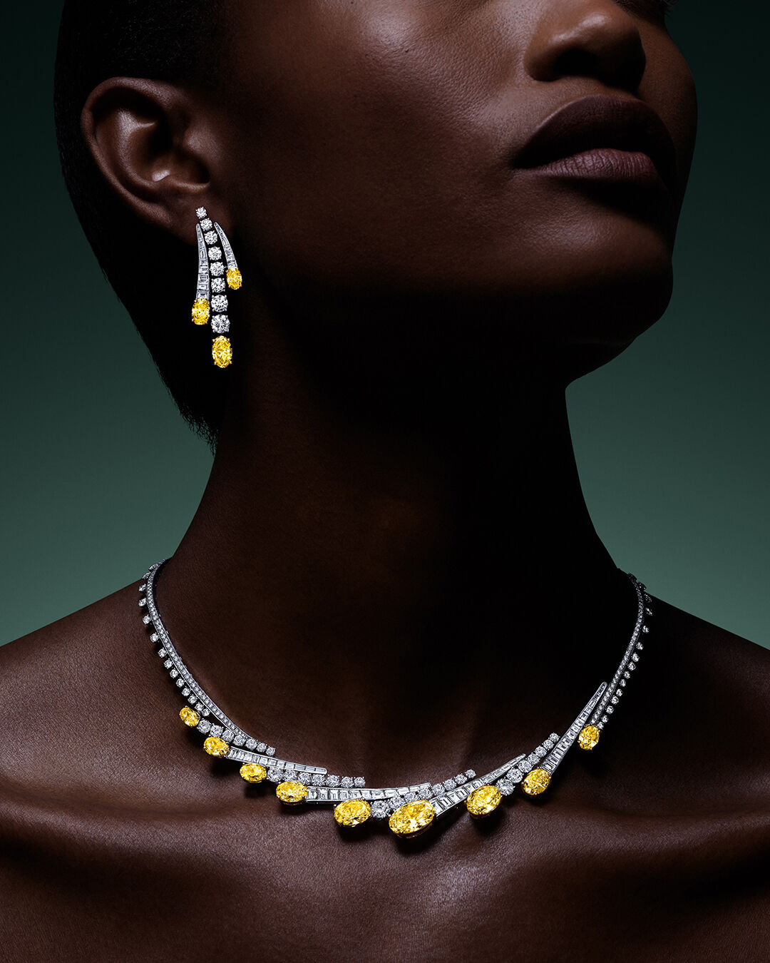 Image shows model wearing Graff Yellow Diamond High Jewellery earrings and necklace