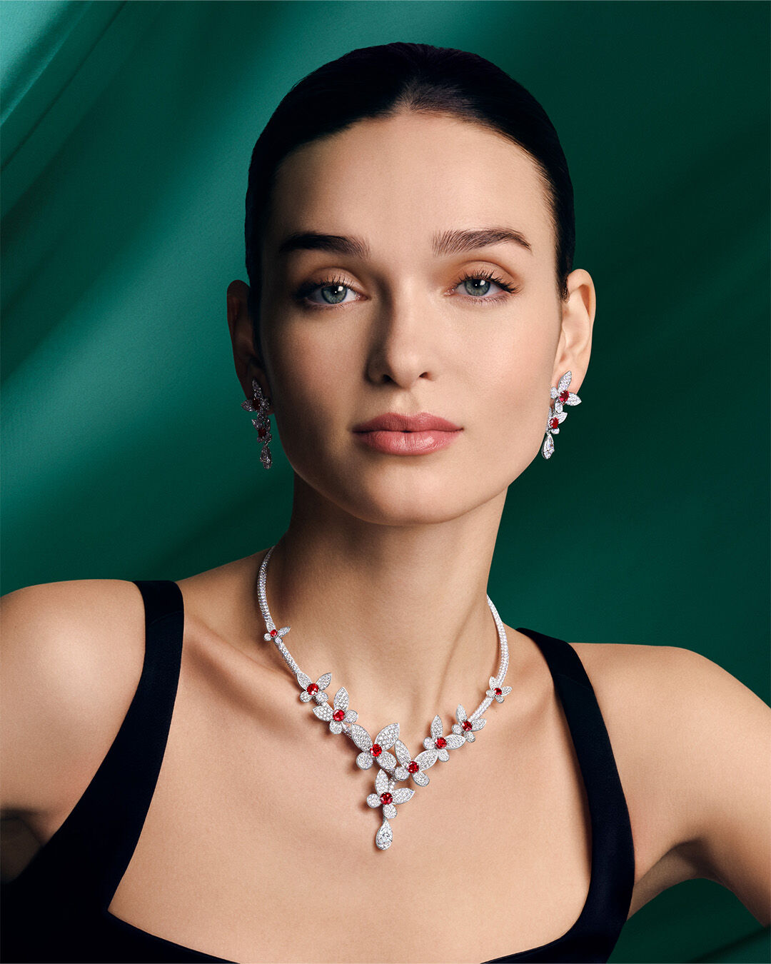 Image shows model wearing Graff Butterfly Ruby and Diamond necklace and earrings