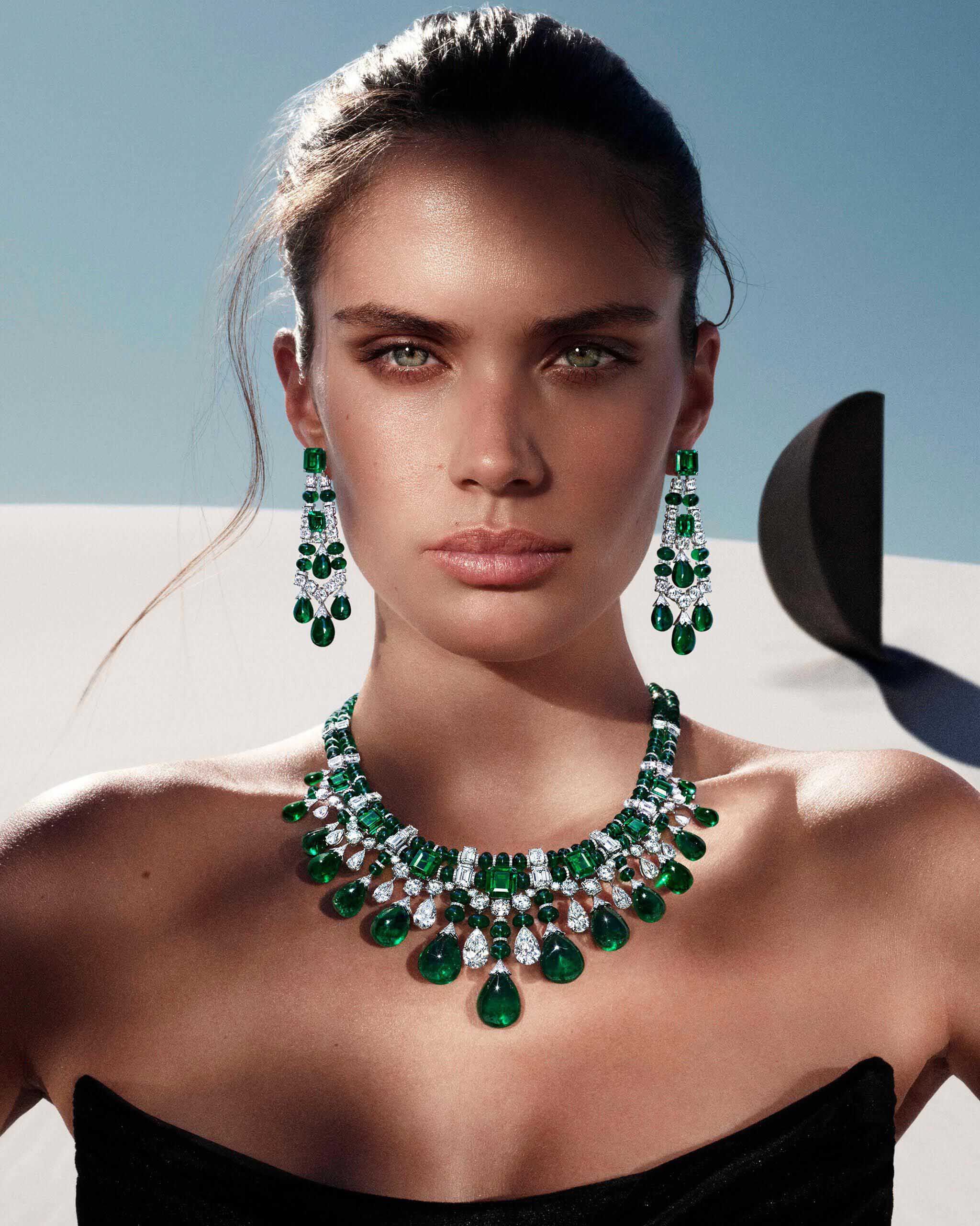 Model wears the Graff Tribal collection emerald and diamond diamond high jewellery earrings and necklace