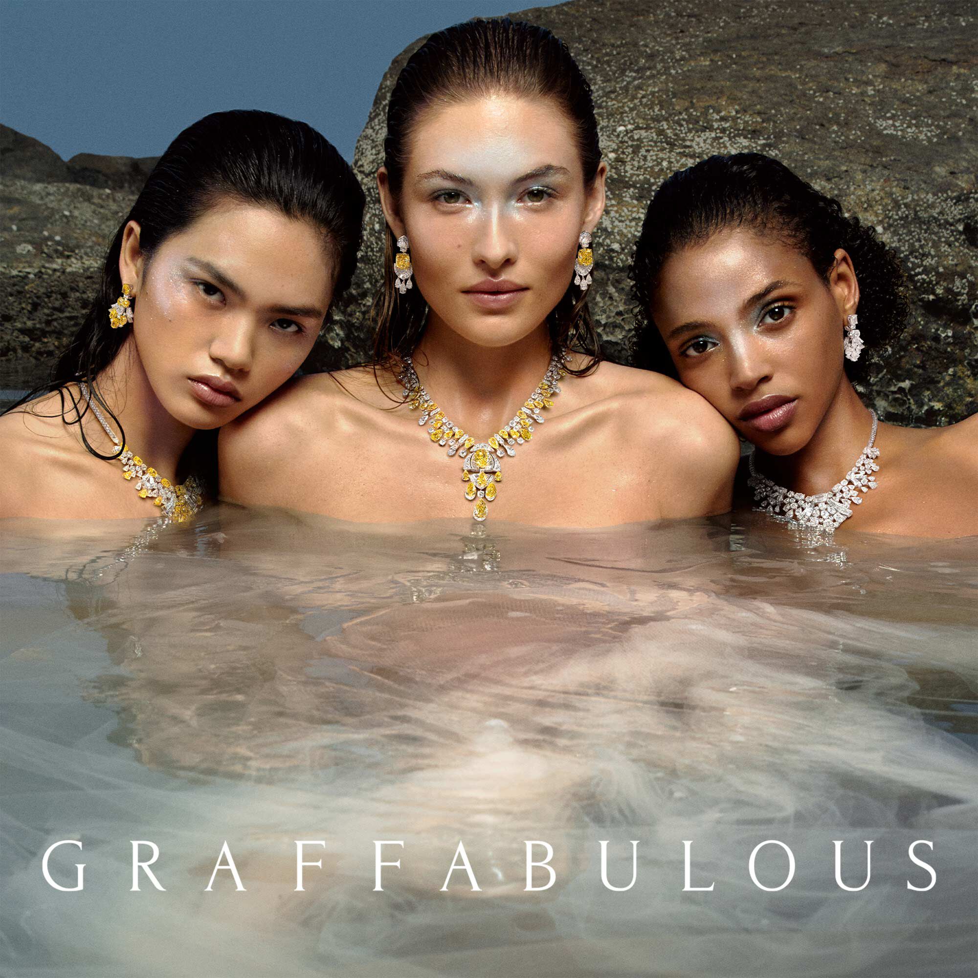 Models wearing yellow and white diamond high jewellery necklaces and earrings in sea