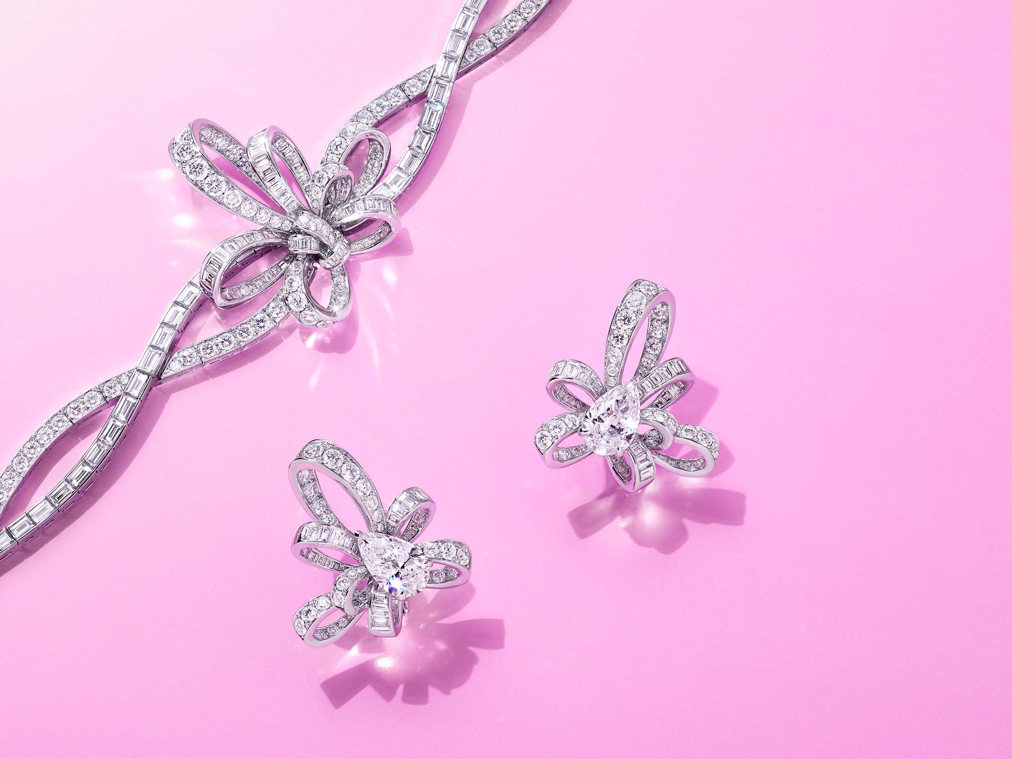 Graff Tilda's Bow jewellery collection diamond earrings and bracelet on a pink background