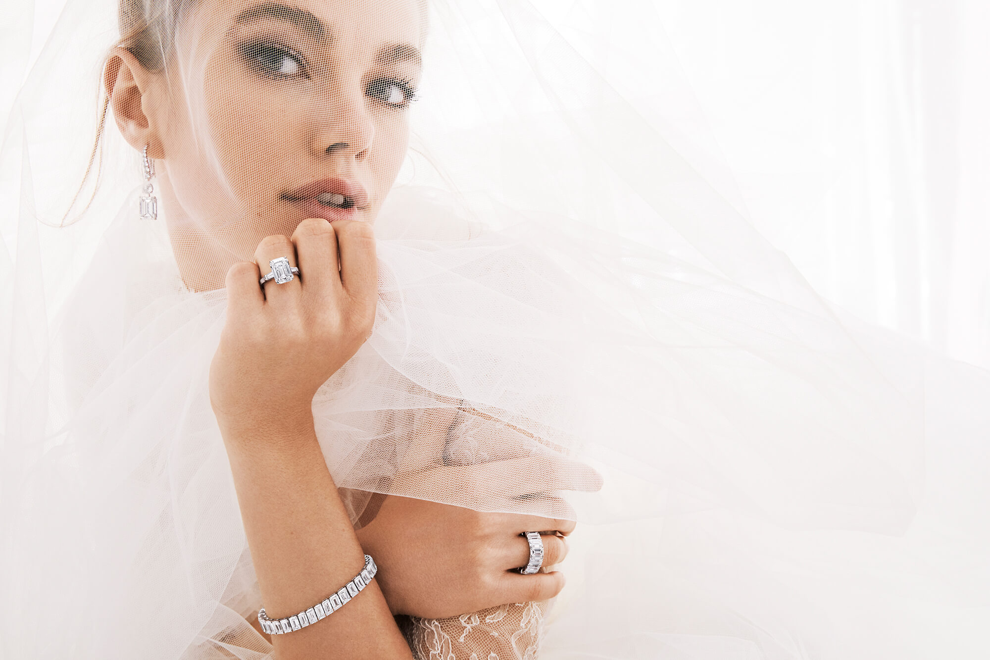 Bride wearing Graff Promise Emerald Cut Diamond Engagement Ring and Graff Emerald Cut Diamond Earrings