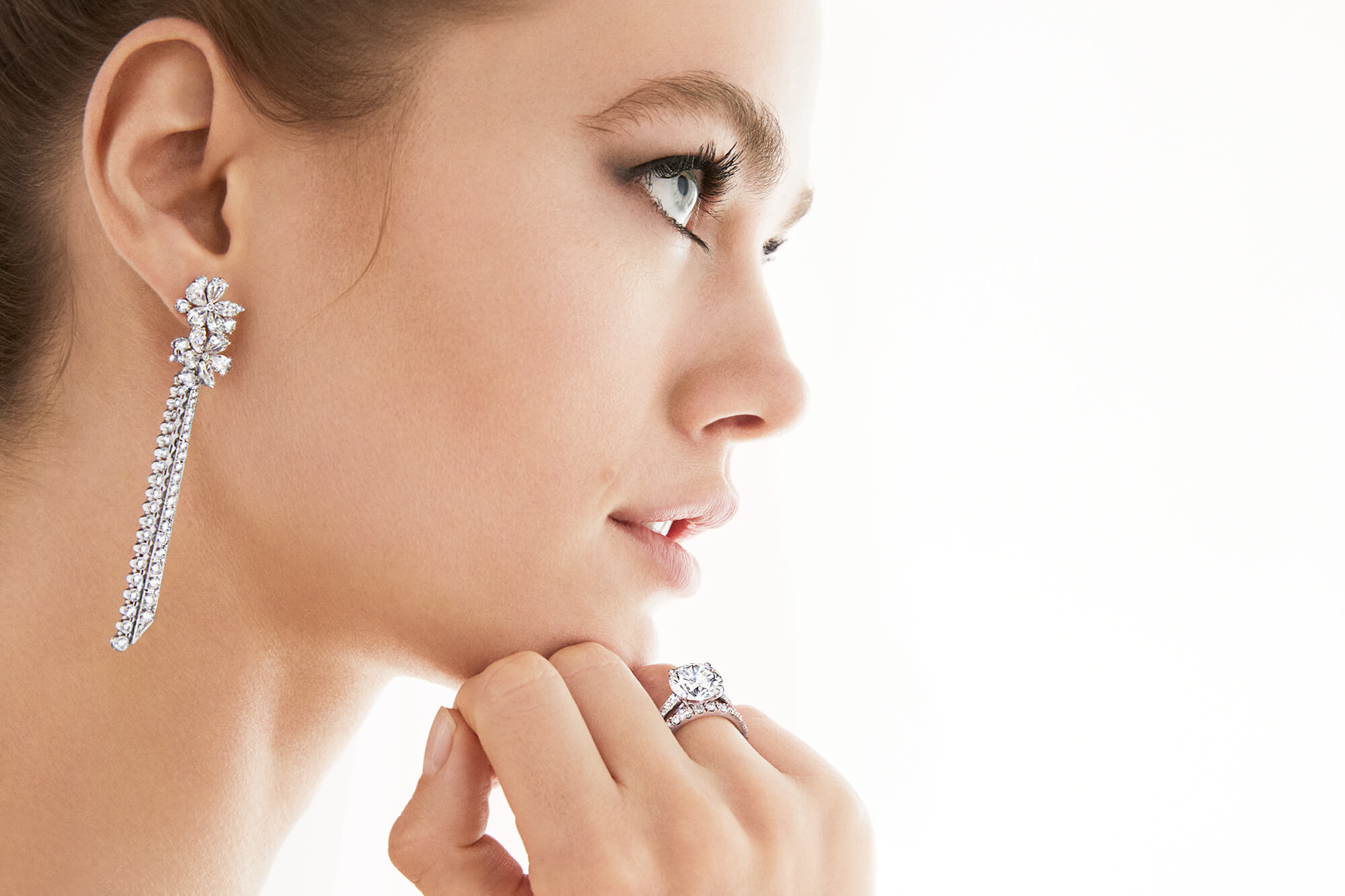 Model wears Carissa Diamond Drop Earrings, round Diamond Solitaire and Castle Set Round Diamond Wedding Band from Graff.
