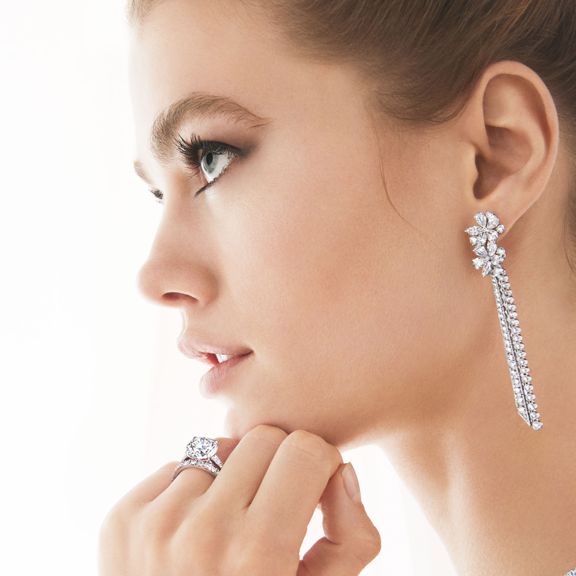 Model wears Graff Carissa Diamond Drop Earrings, round Diamond Solitaire and Castle Set Round Diamond Wedding Band.